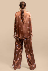 A back view of the Cosmic Print Silk Co-Ord Set, showcasing the blouse's relaxed drape and the wide-leg trousers. The high collar of the blouse and the fluidity of the silk create an elegant, flowing look from behind. The cosmic print continues seamlessly, wrapping around the entire set in a harmonious, celestial design.