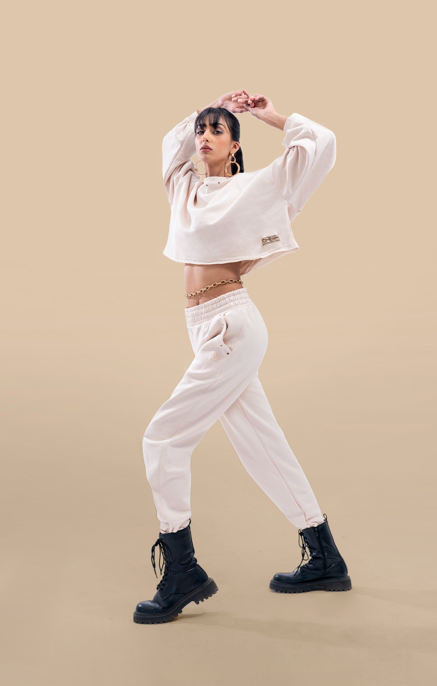Side view of a model wearing the cream crop-top and matching pants, highlighting the flattering fit and trendy design.