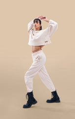 Side view of a model wearing the cream crop-top and matching pants, highlighting the flattering fit and trendy design.