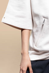  The cream oversized uni fleece t-shirt displayed in studio lighting, showcasing its soft texture and oversized fit.