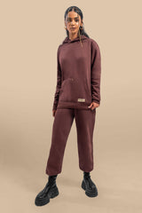 A model wearing the Chestnut Hoodie Uni Co-Ord Set, standing confidently in the hoodie and joggers. The hoodie has a loose, comfortable fit, and the matching joggers complement the relaxed style with an elastic waistband and tapered ankles. The chestnut brown color enhances the casual, stylish appeal.