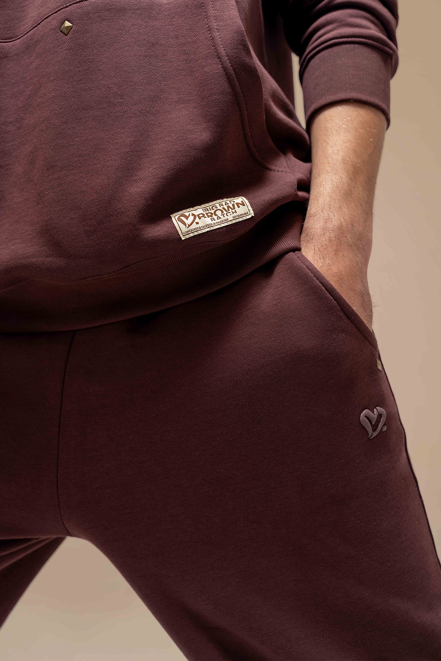 A model wearing the Chestnut Hoodie Uni Co-Ord Set, standing in a relaxed pose. The hoodie and matching joggers give off a comfortable, stylish look, with the model accessorized minimally for an effortless, everyday outfit. The warm chestnut color complements the casual, cozy feel of the set.